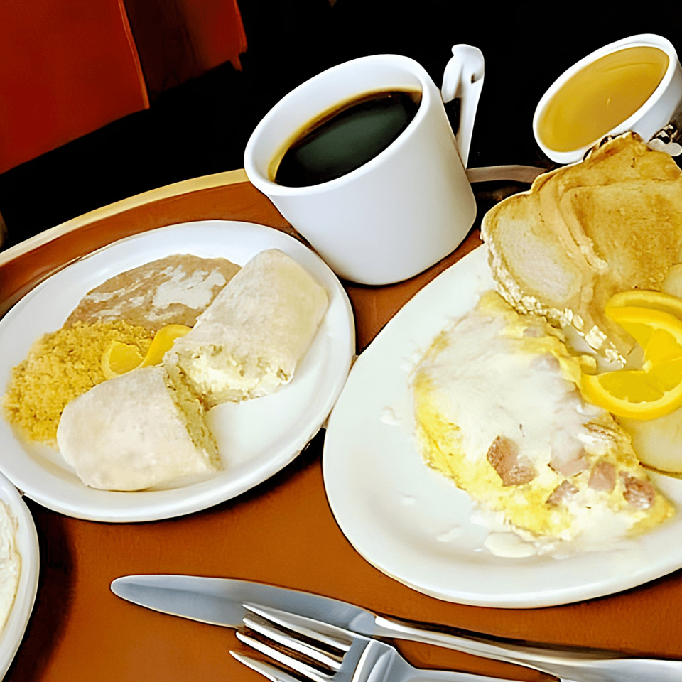 Mexican breakfast with coffee, juice, omelet, toast, and a burrito on a tray.